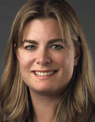 Close-up shot of Jamee, smiling against a gray background.