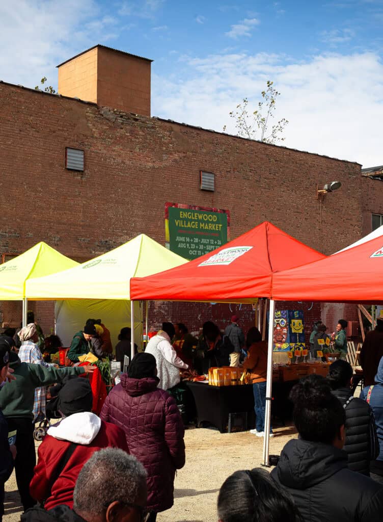 Neighbors shopping and connecting at Englewood Village Market, a community gathering space on Chicago's South Side