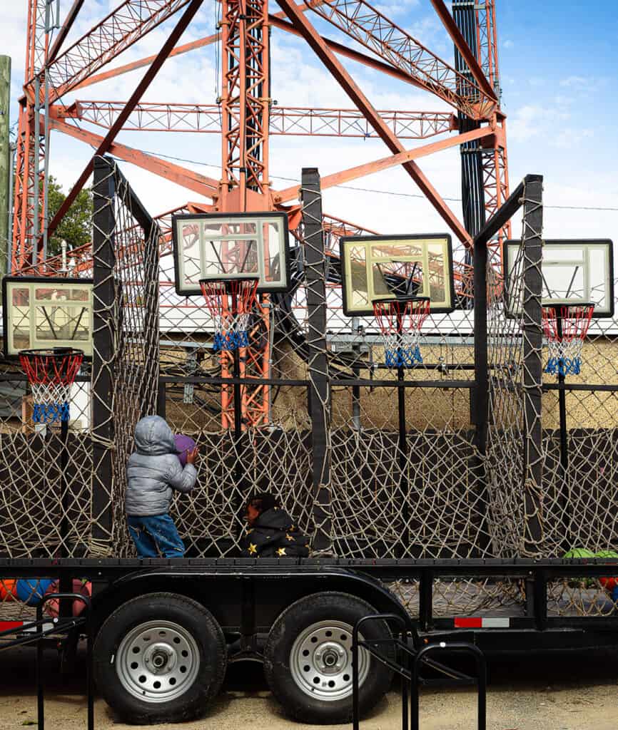 Young person shooting hoops at a portable community basketball court outdoors in Chicago.