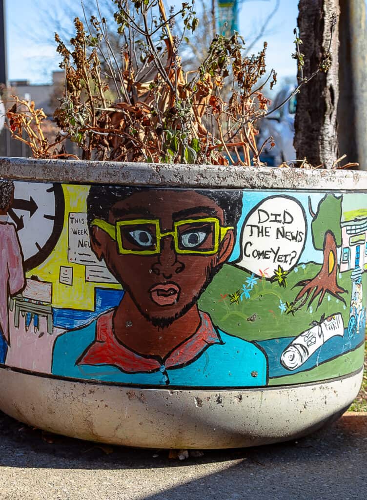A colorful planter in the Bronzeville neighborhood features a male face with the caption, “Did the news come yet?”