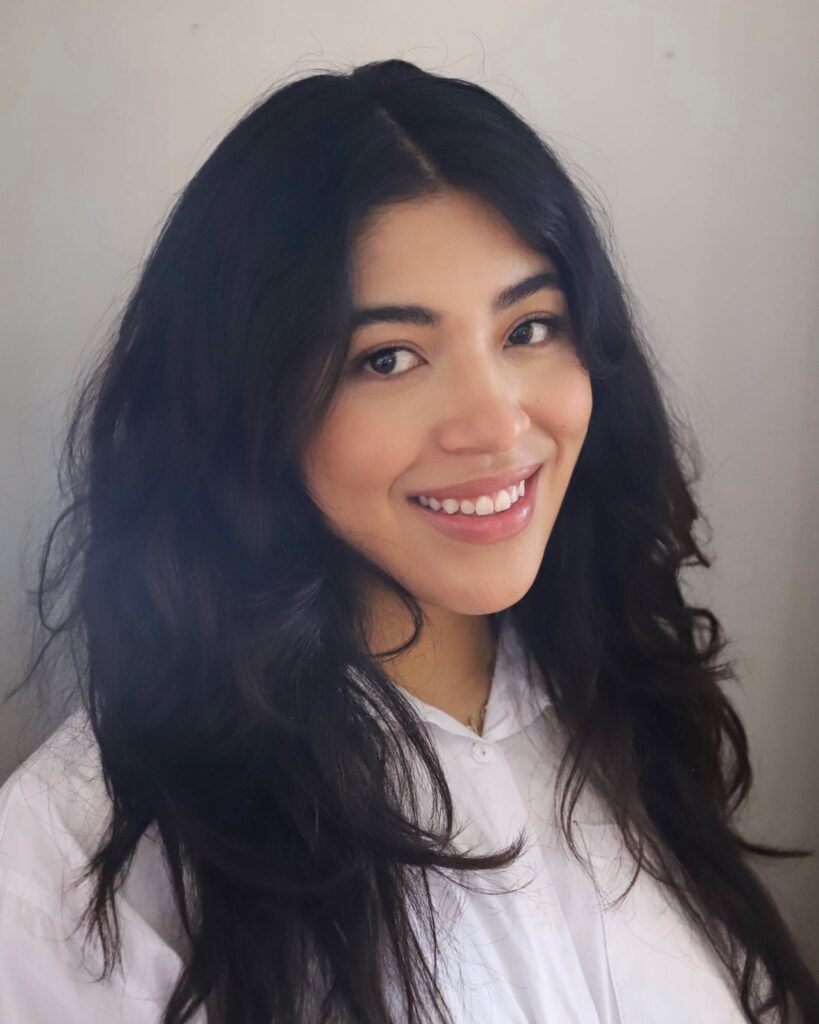 Headshot of Field Fellow Solange Vazconez smiling, wearing a white button-up shirt against a light gray
